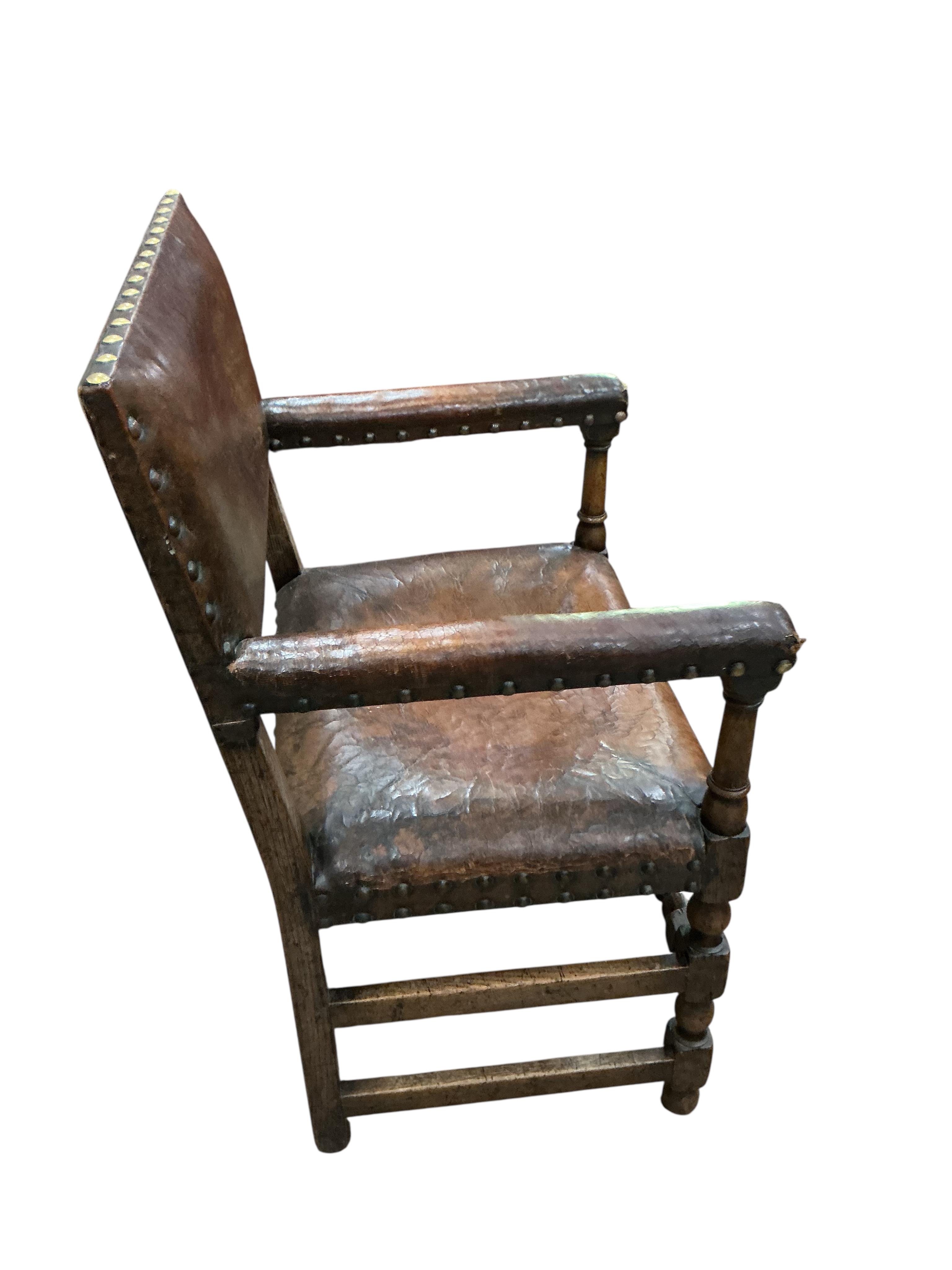 A set of eight Cromwellian style oak and tan leather dining chairs, two with arms